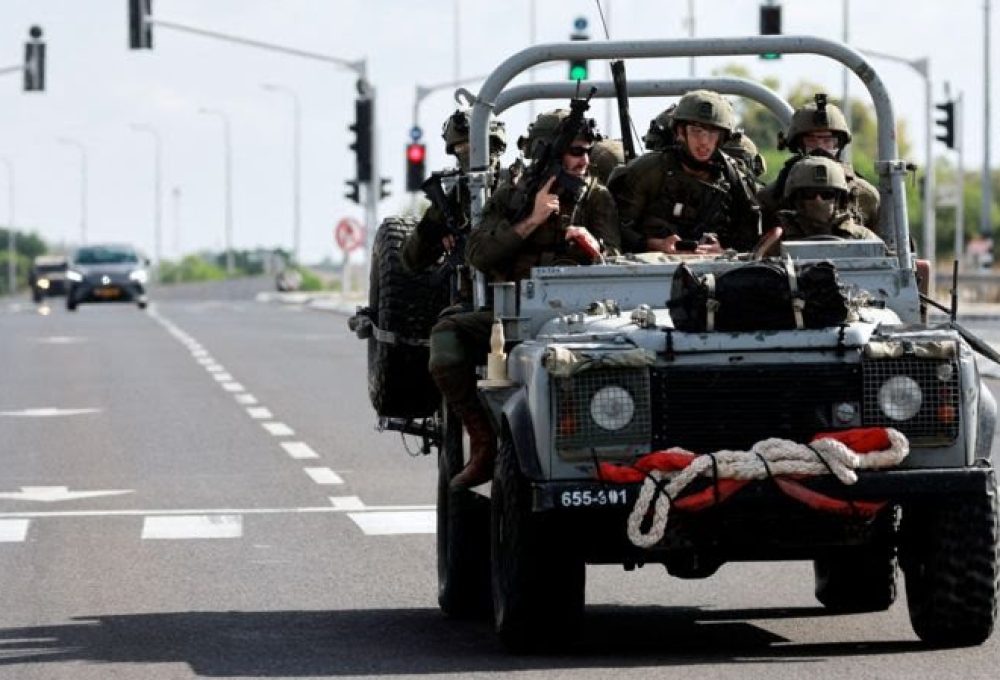 Militares israelenses avançam em uma estrada no sul de Israel, enquanto foguetes são lançados da Faixa de Gaza, nos arredores da cidade de Sderot - CRÉDITO,REUTERS